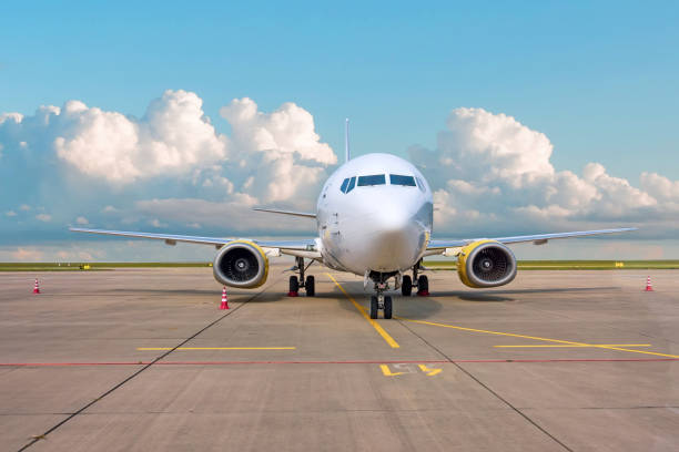 The plane is parked at the airport on a background of clouds